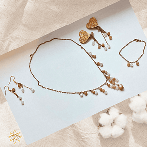 parure lune de miel en pierre de lune et acier inoxydable La parure Lune de miel est une ode à la douceur, à la féminité et à l’intuition. Inspirée par l’énergie apaisante de la lune, elle a été créée comme un bijou-talisman, pensé pour accompagner les femmes dans leur sensibilité, leur équilibre émotionnel et leur reconnexion intérieure. Composée d’un collier, d’un bracelet et de deux paires de boucles d’oreilles (dont une version à clips pour oreilles non percées), cette parure associe la pierre de lune naturelle à l’élégance lumineuse de l’acier inoxydable doré.